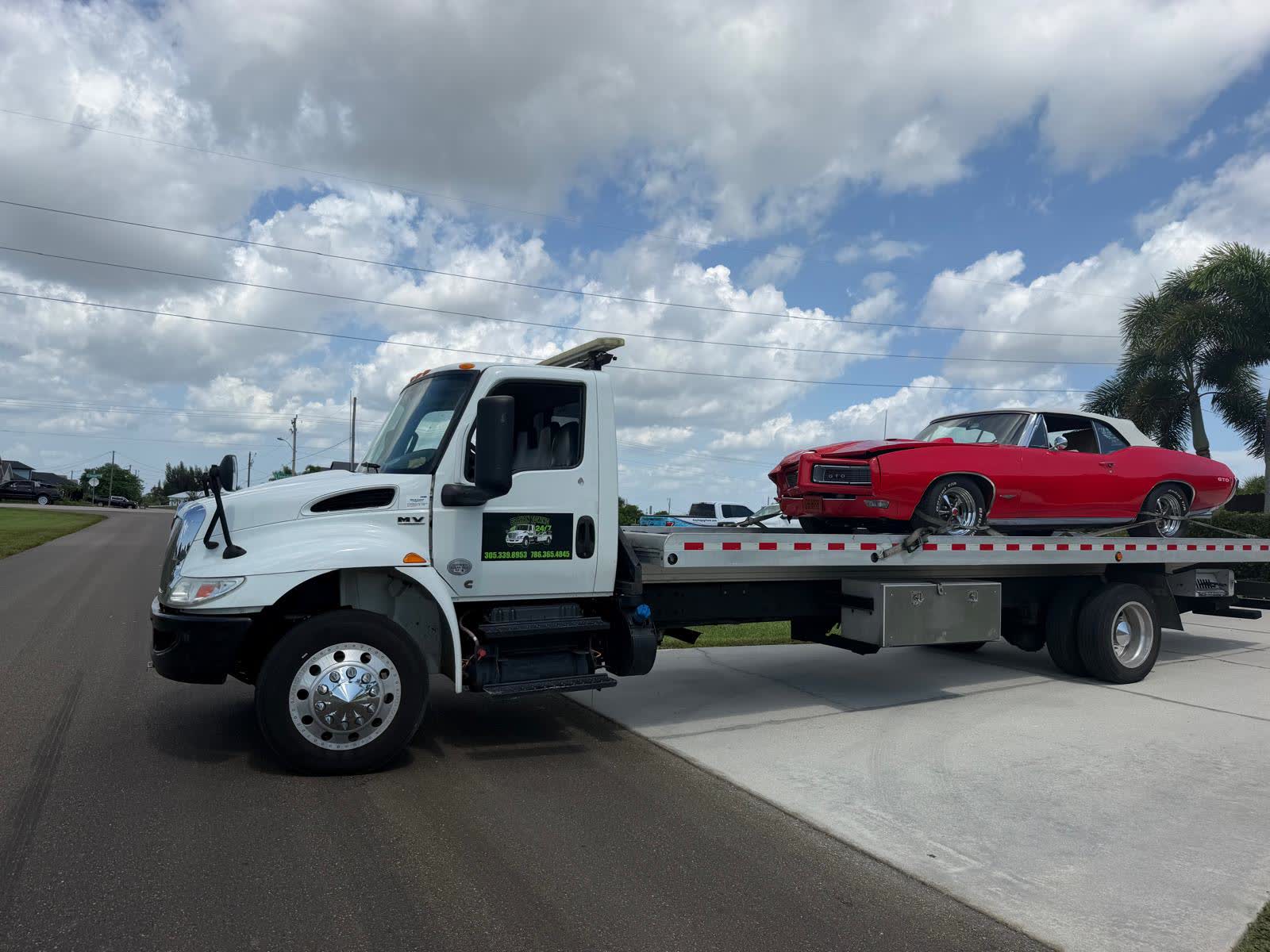 Grúa de plataforma de Brayan Towing cargando un Pontiac GTO clásico en Cape Coral